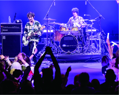 Talent Booking事業で用意した華やかな舞台で演奏するドラマーとギタリスト